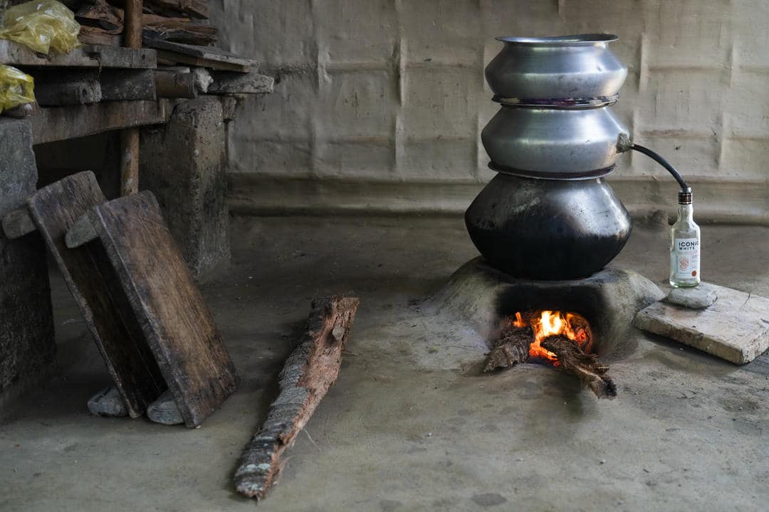 A rustic kitchen scene with firewood and traditional pots used for slow cooking